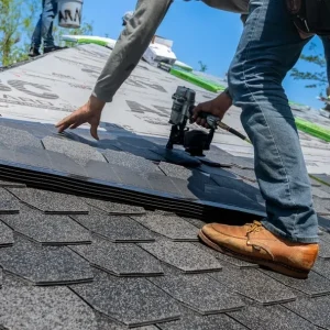 Close-up of a roofer positioning asphalt shingles during installation